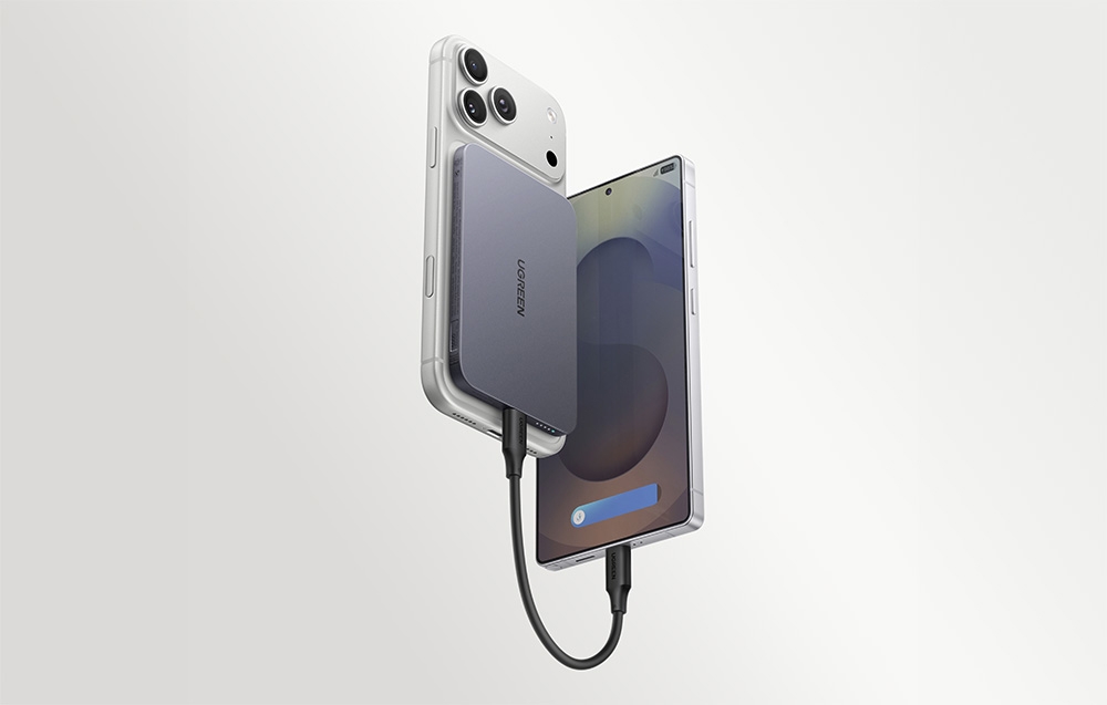 A gray UGREEN power bank attached to a white smartphone and connected by a black cable to a second phone