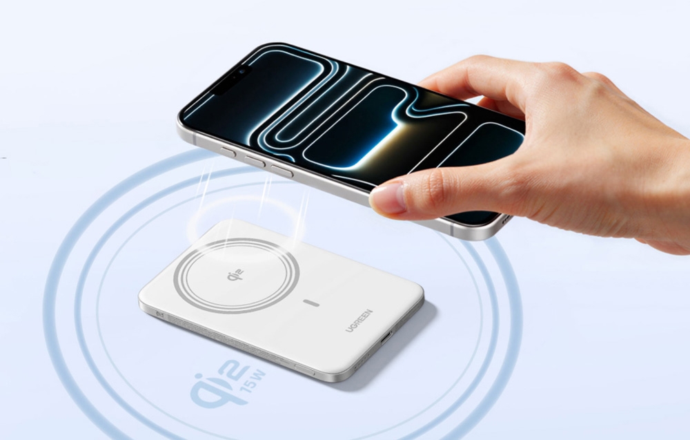Silver smartphone placed against the white Ugreen power bank