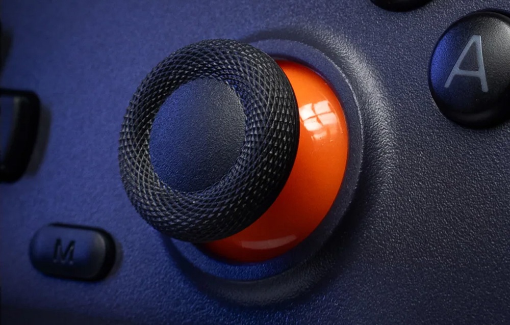 Zbliżenie na analogowy joystick kontrolera do gier z pomarańczowym pierścieniem