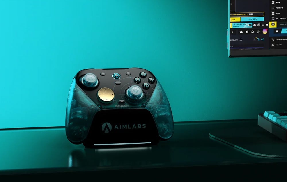 Game controller on the AIMLABS docking station set on a desk next to a monitor and keyboard