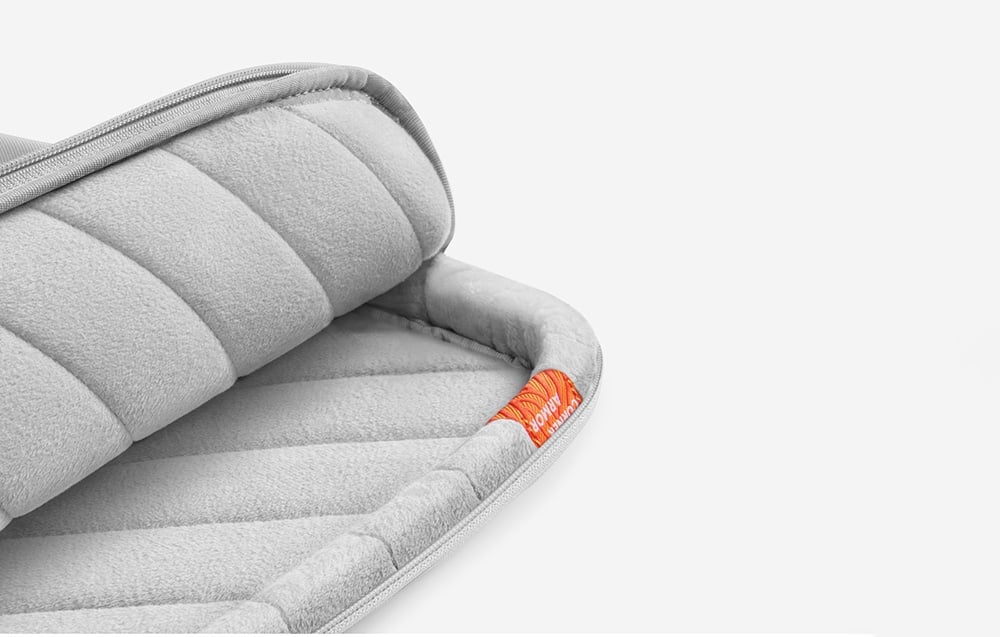 The light gray tomtoc bag opened from the inside, revealing a fluffy, soft interior and orange corner reinforcement.