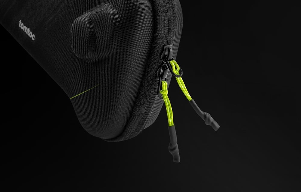 Close-up of a black double zipper with bright green pulls for easy opening.