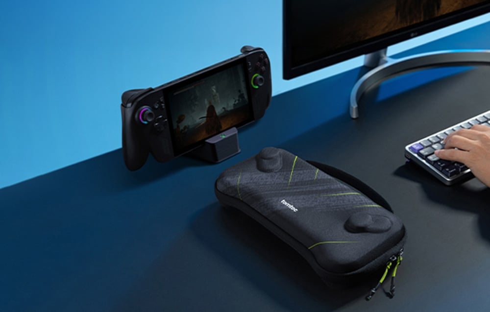 Portable console on a stand with a black case lying next to it on a dark computer desk.