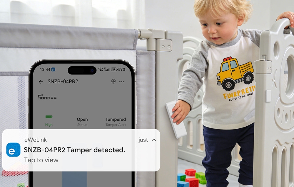 Dziecko wychodzące z łóżeczka, obok smartfon z powiadomieniem