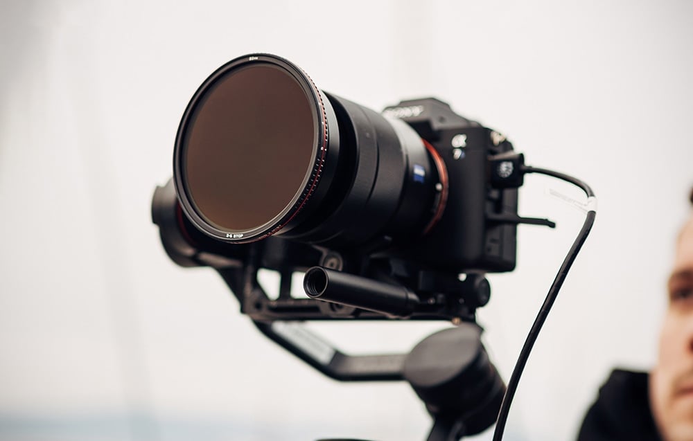 Czarny aparat Sony na gimbalu z założonym na obiektyw kołowym filtrem regulowanym Freewell ND