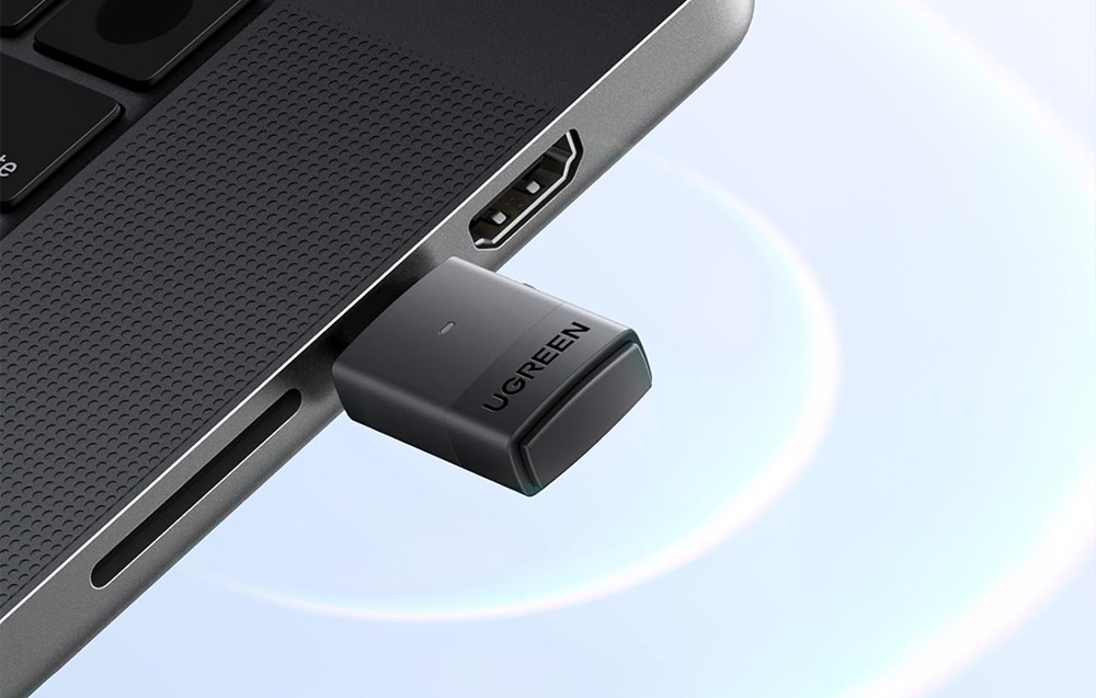 Czarny adapter USB-C marki Ugreen podłączony do bocznego portu laptopa