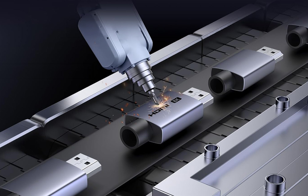 Precyzyjne ramię robota laserowo graweruje napis HDMI 8K na obudowie adaptera na taśmie produkcyjnej