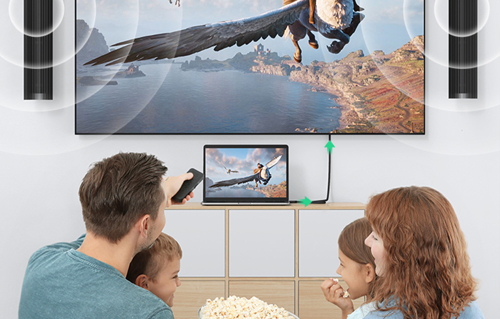 Rodzina oglądająca film z laptopa podłączonego do dużego telewizora wiszącego na ścianie