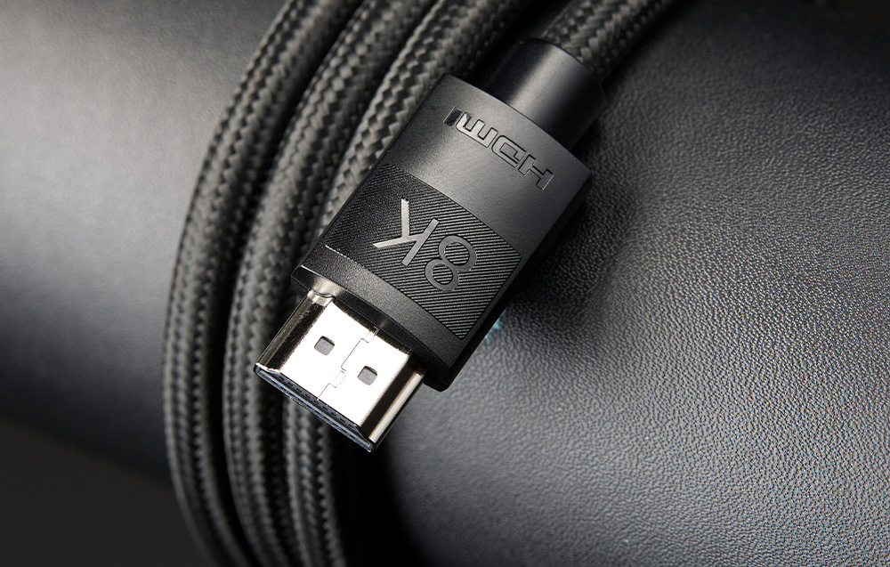 Zbliżenie na czarną wtyczkę kabla HDMI z grawerowanym napisem 8K i HDMI