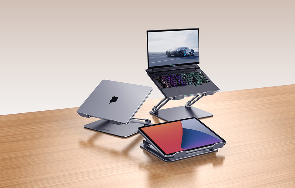 Trzy metalowe podstawki na biurku utrzymujące laptop do gier, zamkniętego laptopa i tablet