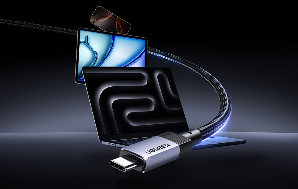 Wtyczka kabla USB-C marki Ugreen z widocznym w tle laptopem, tabletem i smartfonem
