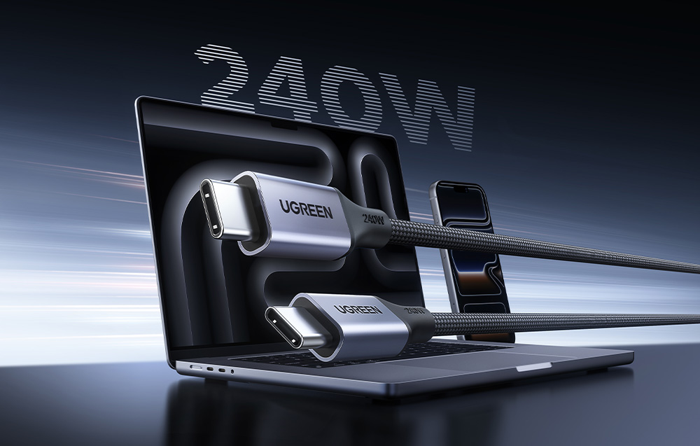 Dwie wtyczki kabla USB-C marki Ugreen na pierwszym planie, na tle otwartego laptopa i smartfona