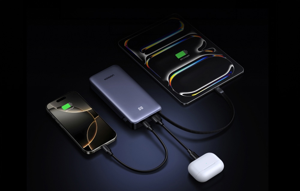 Gray Ugreen power bank charging a smartphone, tablet, and wireless headphone case simultaneously