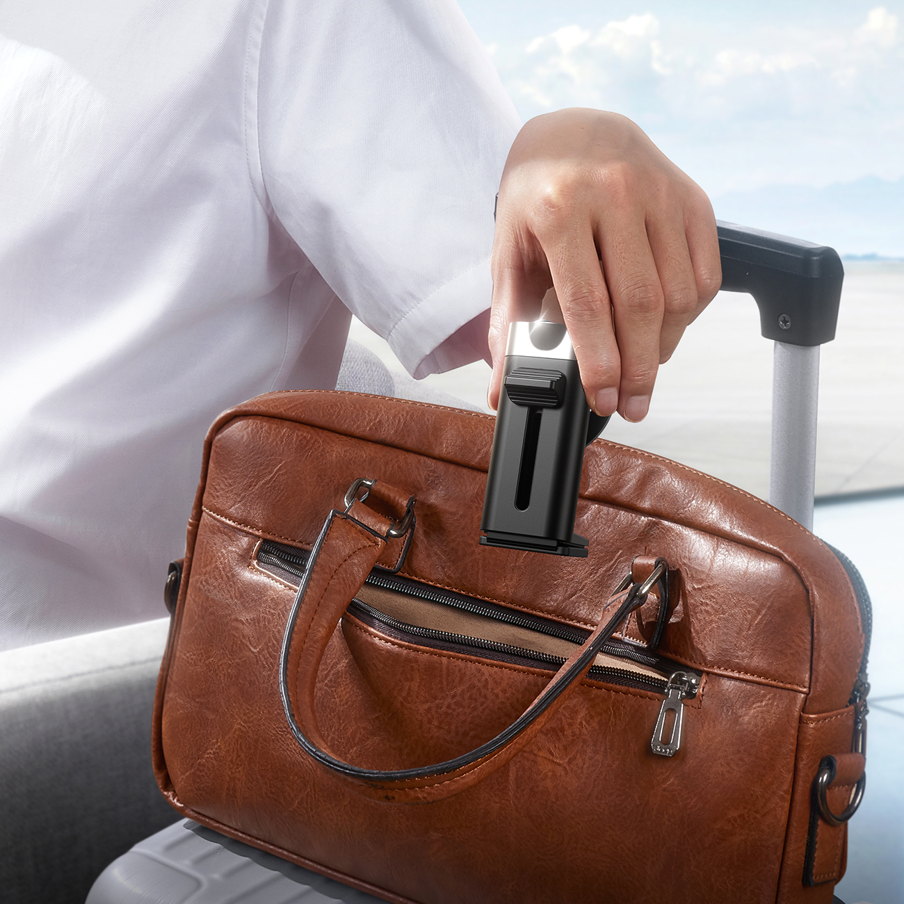 Mężczyzna wkładający kompaktowy stojak Joyroom JR-ZS413 do torby na lotnisku